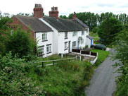 Old cottages on a road that passes under the canal