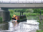 Kids on a barge going under Bamfurlong Road bridge